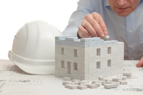 Architect constructing a house with toy blocks Stock Photos