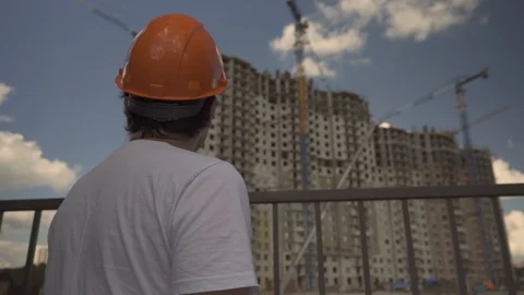 Architect at the construction site.The Builder looks at the building.Builder on Stock Footage 112196454