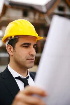 Architect in construction site looking at building plans Stock Photos