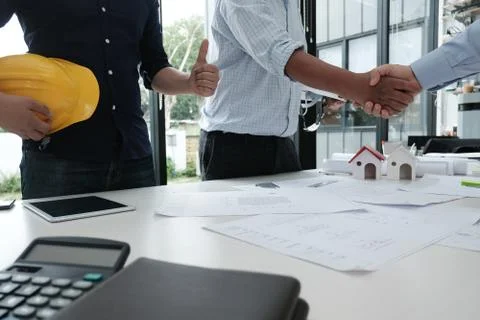 Architect &amp; customer shaking hands. Engineer handshaking with partner for suc Stock-Fotos