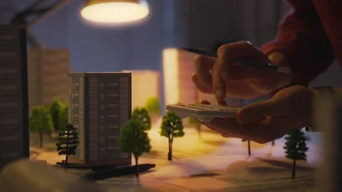 The architect-designer is busy with calculations using a calculator late at Stock Footage 272152543