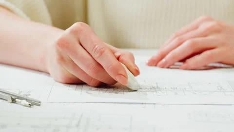 Architect designer drawing plan blueprint close-up, using eraser. Professional Stock Footage 185577617