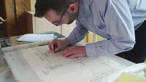 Architect designer erasing notes from the construction plan. Stock Footage 180532235