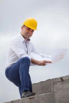 Architect designing a building standing on construction site Stock Photos
