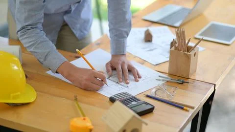 The architect is designing the construction. He drafts the floor plan to pr.. Foto stock