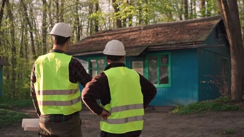 The architect discusses with the builders the plan for the house Stock Footage 241738641