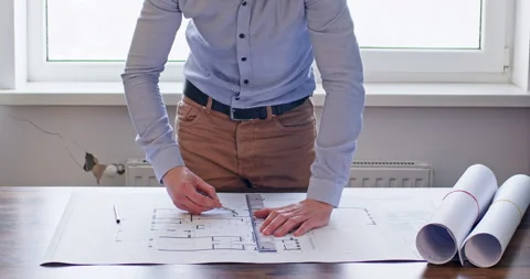 Architect drafts plan of important building project at table Stockbeeldmateriaal 243726348