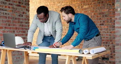Architect, drawing and men with laptop in building, discussion and planning for Stock Footage 338395814