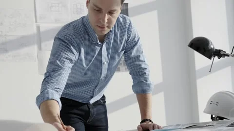 Architect draws a blueprint, standing in front of the table. Stock Footage 256694026