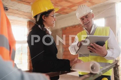 Architect Engineer And Manual Worker Meeting In Construction Site Stock Photos