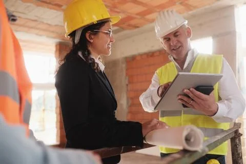 Architect Engineer And Manual Worker Meeting In Construction Site Stock Photos