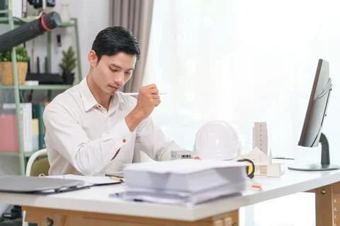 Architect engineer man working on architectural plan project in office. Stock Photos