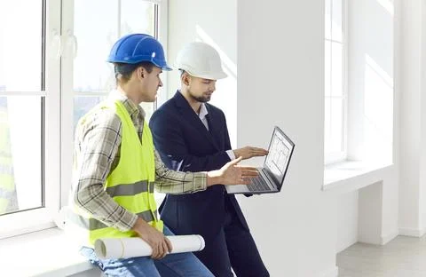 Architect, engineer or designer showing foreman design project on laptop Stock Photos