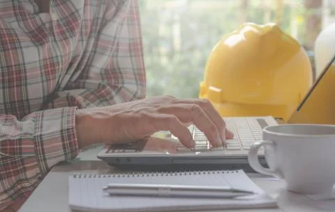 Architect engineer using laptop for working with yellow helmet, laptop and co Stock Photos