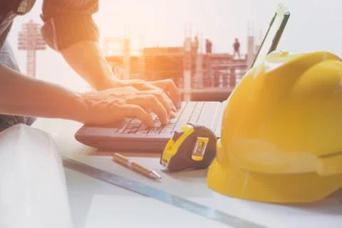 Architect engineer using laptop for working with yellow helmet, laptop and co Stock Photos