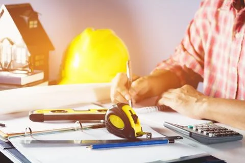 Architect engineer working concept with blueprint, yellow helmet and tools on Stock Photos