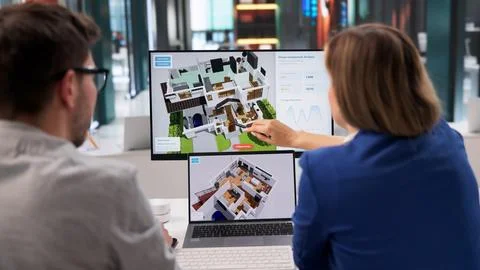 Architect Examines 3D Home Model On Computer For Renovation Plan Stock Photos