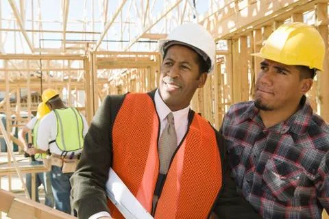 Architect With Foreman Inspecting Framework Stock Photos