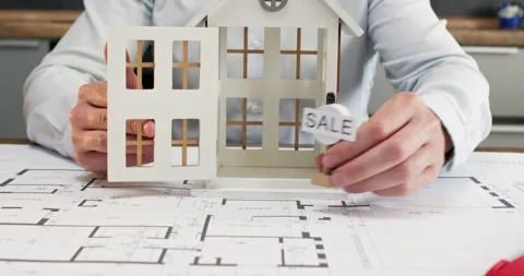 Architect gently opens front door of house model put on drawing Video stock 314730795