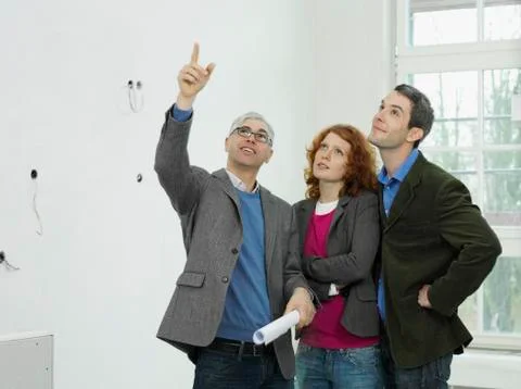 An architect going over blueprints with a young couple Fotos Stock