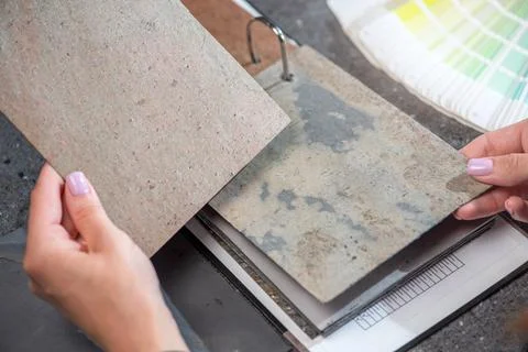 Architect hand choosing sample of stone material or tile texture collection on Stock Photos