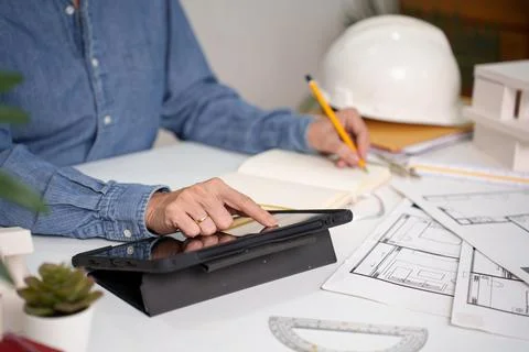 Architect Hands Using Tablet for Building Plan with Blueprint and Hard Hat .. Stock Photos