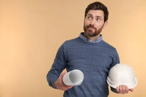 Architect with hard hat and draft on beige background, space for text Stock Photos