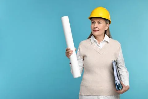 Architect in hard hat with draft and folder on light blue background, space.. Stock Photos