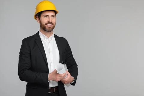 Architect in hard hat with draft on gray background, space for text Stock Photos