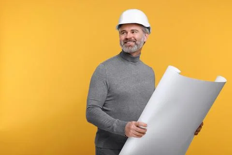 Architect in hard hat holding draft on orange background. Space for text Stock Photos