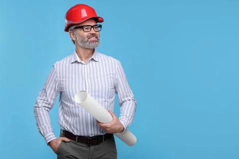 Architect in hard hat holding draft on light blue background. Space for text Stock Photos