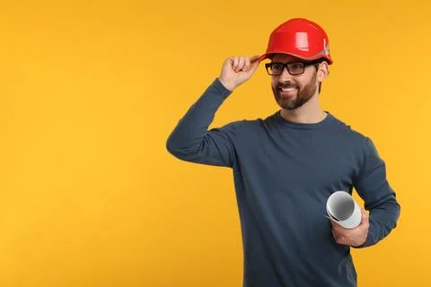 Architect in hard hat holding draft on orange background, space for text Stock Photos