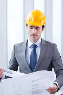 Architect in hardhat with blueprint Stock Photos