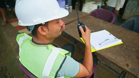 Architect has cup of coffee while talking by walkie talkie Stock Footage 297600877