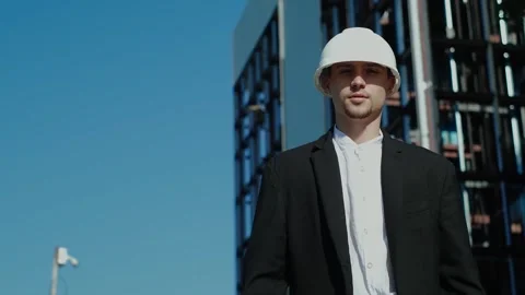 An architect in a helmet and jacket inspects a construction site. Tracking shot Stock Footage 249263115