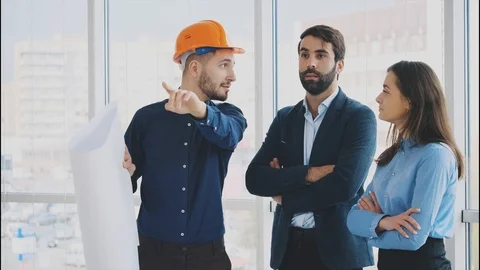 An architect with his colleagues talks about a business project while having Video stock 102392258