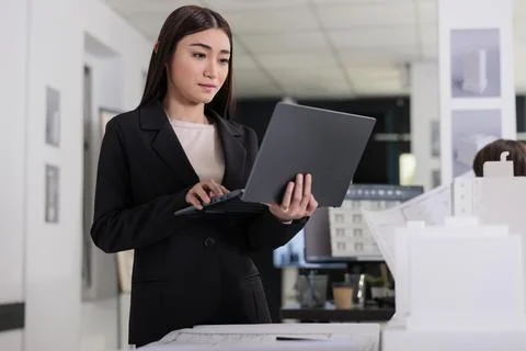 Architect holding laptop, using building modeling software Stockfoto's