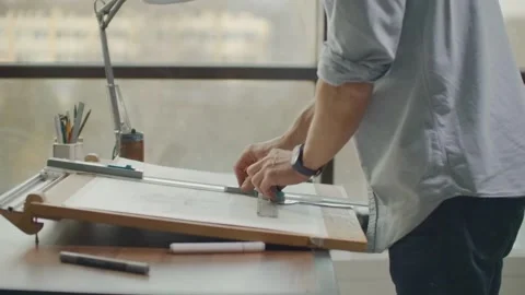 Architect Holds Pencil In His Hand And Stands At Drawing Table. Person Works Stock Footage 336573189