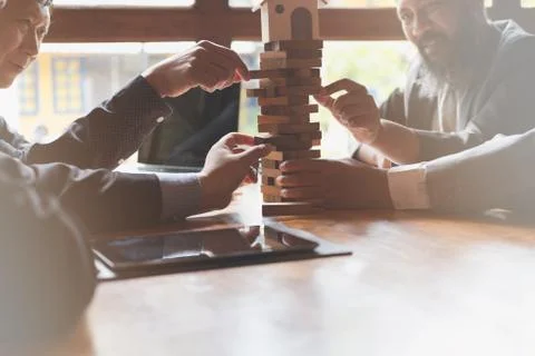 Architect, house developer and businessman pulling out wood building block fr 스톡 사진