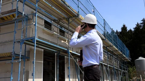 Architect inspects construction outside talking on the phone Stock-Footage 107558401