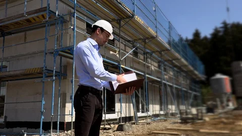 Architect inspects construction outside talking on the phone Stock Footage 107559508
