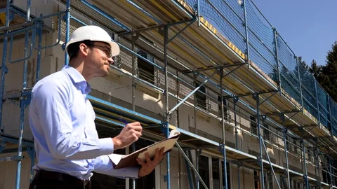 Architect inspects construction outside talking on the phone 動画素材 107559700