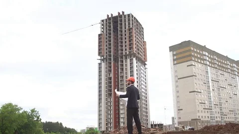 Architect looking at building plans with new construction Stock Footage