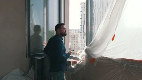 The architect looks out of the apartment window Stock Footage 160933378