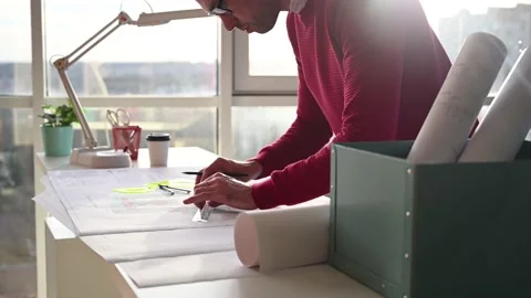 Architect makes corrections on drawing at table with pencil and ruler Stock Footage 143481553