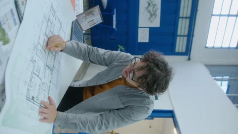 Architect Making Notes on Floor Plan during Office Workday Stock Footage 248173660