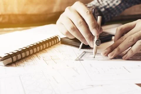 Architect man drawing geometric shape on sheet of paper at office table. Stock Photos