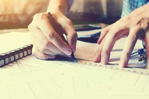 Architect man drawing geometric shape on sheet of paper at office table. Stock Photos