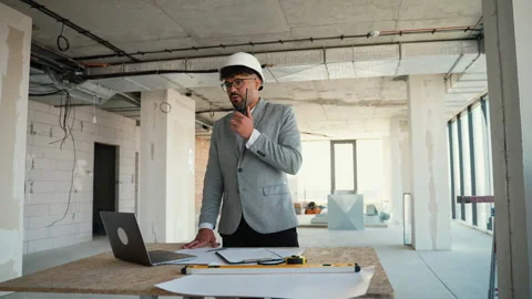 Architect managing construction project while discussing on phone Stock Footage 312833503