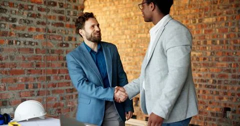 Architect, men and handshake on construction site, teamwork and agreement f.. 库存照片